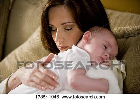 Close-up of a sleeping mother holding a sleeping infant on her shoulders View Large Photo Image Stock Photograph - Close-up of a sleeping mother holding a sleeping infant on her shoulders. Fotosearch
