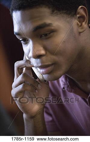 Close-up of a young African American man using cellphone View Large Photo Image Stock Photo - Close-up of a young African American man using cellphone. Fotosearch