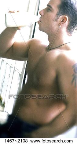 Stock Photo - Close-up of a young man drinking milk from a bottle. Fotosearch