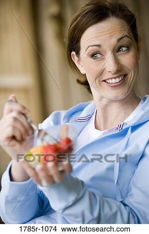 Close-up of a young woman holding a bowl of fresh fruit View Large Photo Image Picture - Close-up of a young woman holding a bowl of fresh fruit. Fotosearch