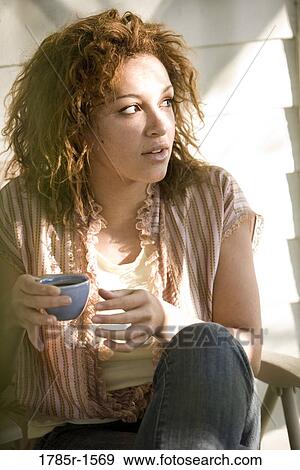 Stock Photo - Close-up of a young woman holding an espresso cup. Fotosearch