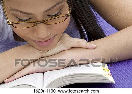 Stock Image - Close-up of a young woman reading a book. Fotosearch