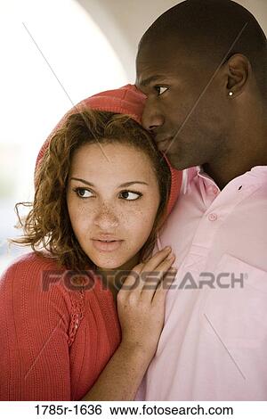 Stock Photograph - Close-up of a young woman resting her head on a man's shoulder. Fotosearch