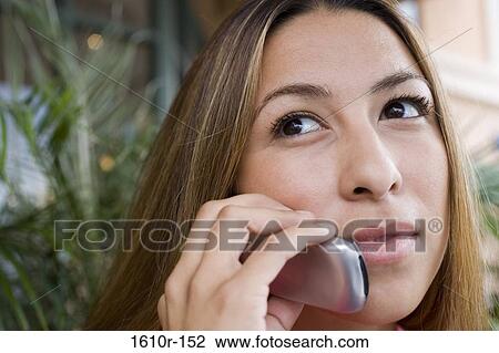 Stock Image - Close-up of a young woman talking on a mobile phone. Fotosearch