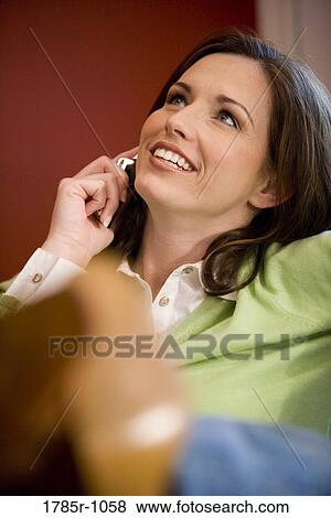 Close-up of a young woman talking on mobile phone View Large Photo Image Stock Photo - Close-up of a young woman talking on mobile phone. Fotosearch