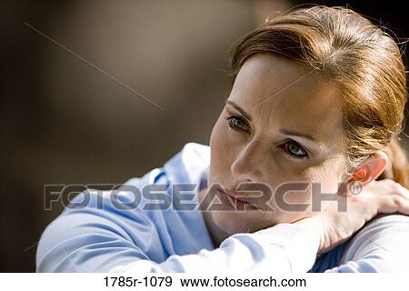 Close-up of a young woman thinking View Large Photo Image Stock Photo - Close-up of a young woman thinking. Fotosearch