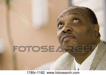 Stock Image - Close-up of an African American mature man looking up. Fotosearch