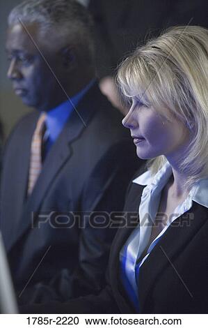 Stock Image - Close-up of business colleagues in front of computer monitor. Fotosearch