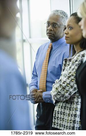 Close-up of business colleagues standing together View Large Photo Image Stock Photo - Close-up of business colleagues standing together. Fotosearch