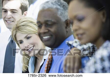 Close-up of business colleagues standing in a row, focus on woman View Large Photo Image Stock Photograph - Close-up of business colleagues standing in a row, focus on woman. Fotosearch