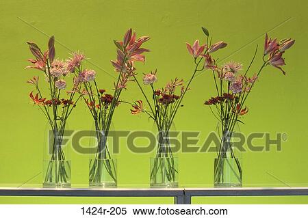 Stock Photography - Close-up of flowers in four vases on a shelf. Fotosearch