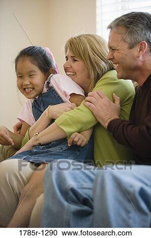 Stock Image - Close-up of parents with daughter. Fotosearch