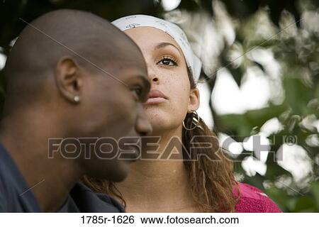 Stock Photograph - Close-up of serious young multi-ethnic couple outdoors. Fotosearch