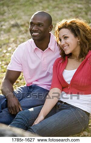 Close-up of smiling young multi-ethnic couple outdoors View Large Photo Image Stock Photo - Close-up of smiling young multi-ethnic couple outdoors. Fotosearch