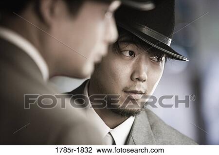 Close-up of two young Asian men wearing suits and hats View Large Photo Image Stock Image - Close-up of two young Asian men wearing suits and hats. Fotosearch