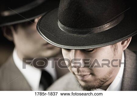 Close-up of two young Asian men wearing suits and hats View Large Photo Image Stock Photo - Close-up of two young Asian men wearing suits and hats. Fotosearch