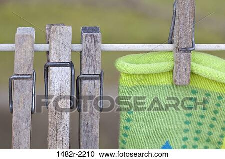 Stock Image - Close up of wooden clothespins on clothes line. Fotosearch