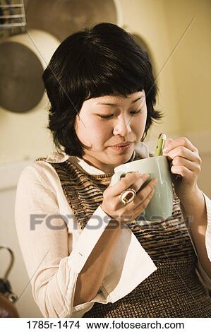 Close-up of young Asian woman drinking from a cup View Large Photo Image Picture - Close-up of young Asian woman drinking from a cup. Fotosearch