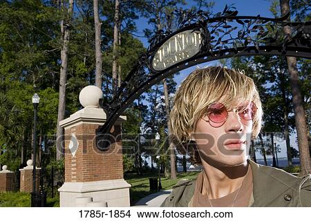 Close-up of young man outside a park View Large Photo Image Picture - Close-up of young man outside a park. Fotosearch