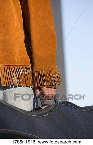Close-up view of a young man's hands carrying a guitar case View Large Photo Image Stock Photography - Close-up view of a young man's hands carrying a guitar case. Fotosearch