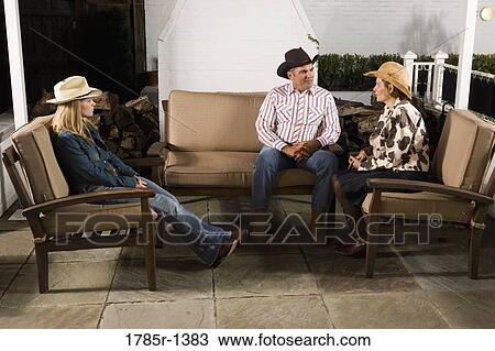 Stock Image - Country family sitting on a sofa. Fotosearch