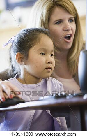 Stock Image - Daughter and mother looking at a computer. Fotosearch
