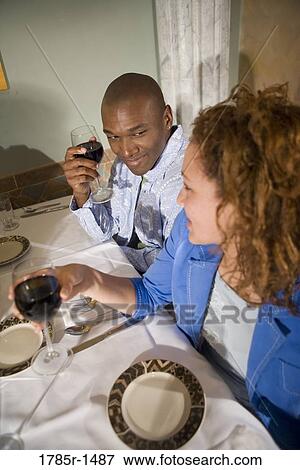Elevated view of a young couple sitting at a restaurant table drinking wine View Large Photo Image Stock Photo - Elevated view of a young couple sitting at a restaurant table drinking wine. Fotosearch