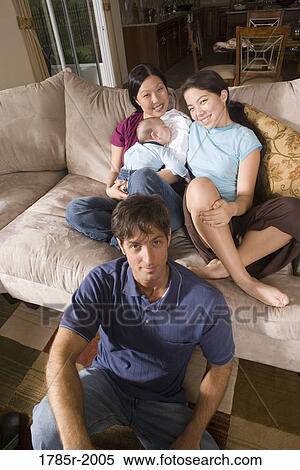 Elevated view of an Asian-Caucasian family sitting on sofa and the floor View Large Photo Image Stock Photography - Elevated view of an Asian-Caucasian family sitting on sofa and the floor. Fotosearch