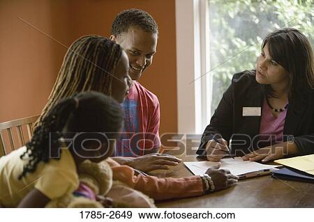 Family at home signing papers with agent View Large Photo Image Stock Photo - Family at home signing papers with agent. Fotosearch