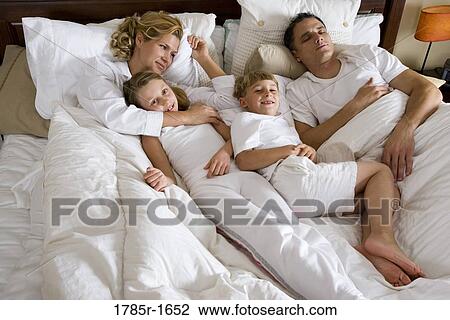 Family in bed waking up in the morning View Large Photo Image Stock Image - Family in bed waking up in the morning. Fotosearch