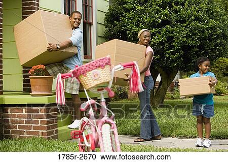 Stock Image - Family moving boxes into house. Fotosearch