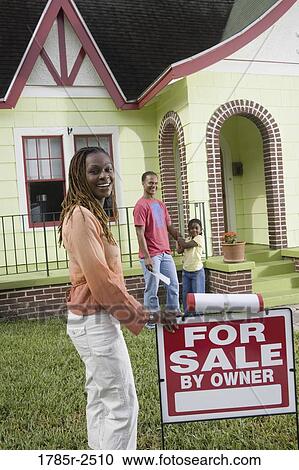 Family outside house with woman standing by "For Sale" sign View Large Photo Image Stock Image - Family outside house with woman standing by "For Sale" sign. Fotosearch
