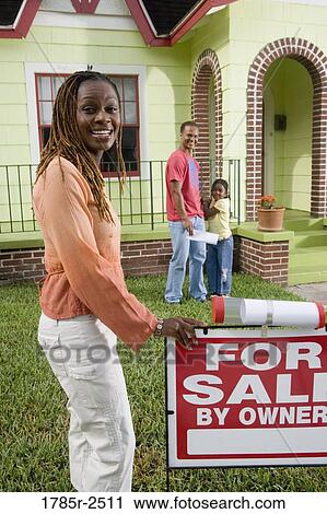 Family outside house with woman standing by "For Sale" sign View Large Photo Image Stock Image - Family outside house with woman standing by "For Sale" sign. Fotosearch