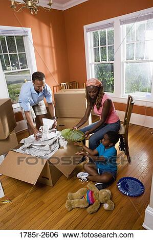 Family packing or unpacking belongings from box View Large Photo Image Stock Photograph - Family packing or unpacking belongings from box. Fotosearch