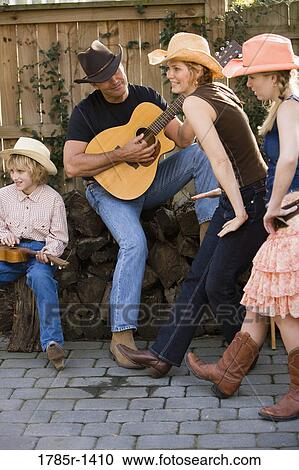 Stock Image - Family playing country music and dancing. Fotosearch