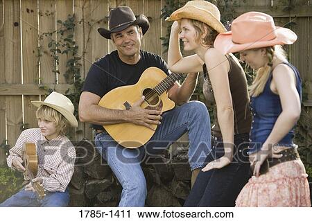 Stock Image - Family playing country music and dancing. Fotosearch