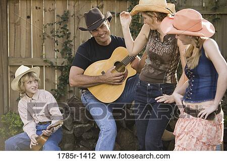 Stock Image - Family playing country music and dancing. Fotosearch