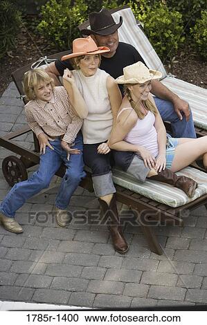 Stock Image - Family relaxing wearing country western clothing. Fotosearch