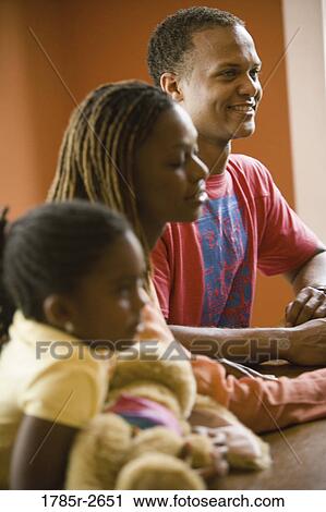 Family sitting inside a house View Large Photo Image Stock Image - Family sitting inside a house. Fotosearch