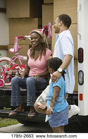 Stock Image - Family standing near a moving truck. Fotosearch