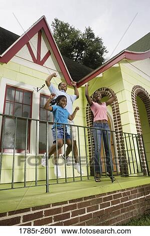 Family standing outside house View Large Photo Image Stock Image - Family standing outside house. Fotosearch