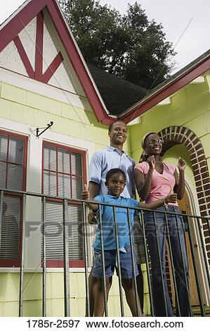Family standing outside house View Large Photo Image Stock Photo - Family standing outside house. Fotosearch