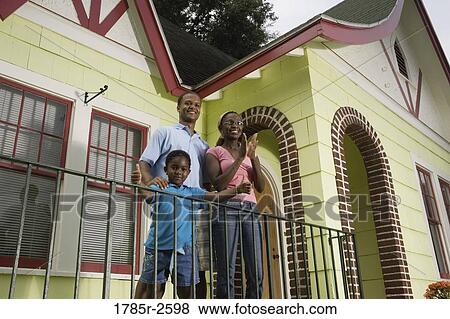 Stock Photo - Family standing outside house. Fotosearch