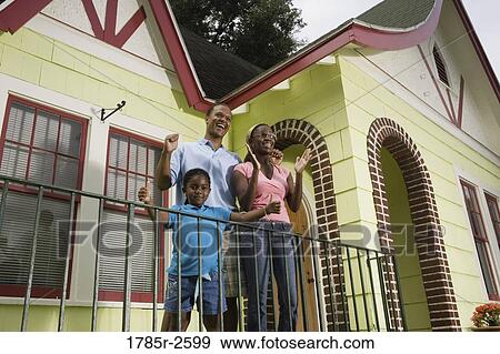 Family standing outside house View Large Photo Image Stock Photo - Family standing outside house. Fotosearch