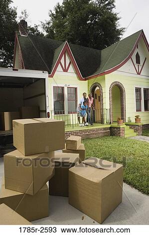 Family standing outside house, with moving boxes piled in driveway View Large Photo Image Stock Image - Family standing outside house, with moving boxes piled in driveway. Fotosearch
