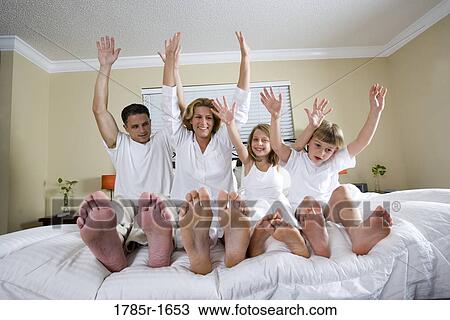 Family stretching up on bed View Large Photo Image Stock Image - Family stretching up on bed. Fotosearch