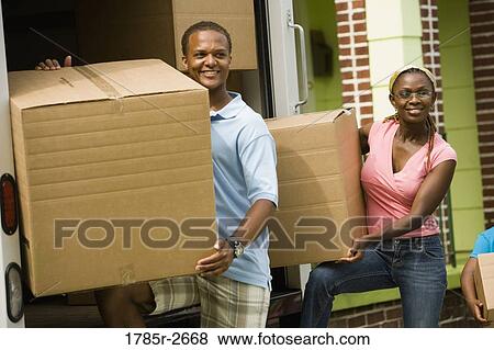 Family unloading boxes from a moving truck View Large Photo Image Stock Photo - Family unloading boxes from a moving truck. Fotosearch