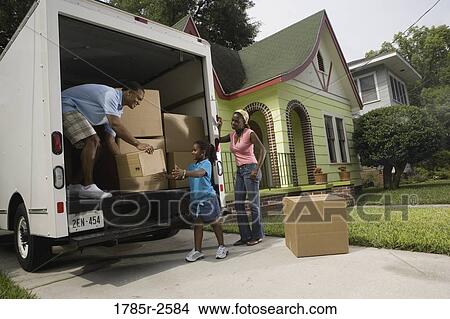 Picture - Family unloading boxes from moving truck. Fotosearch