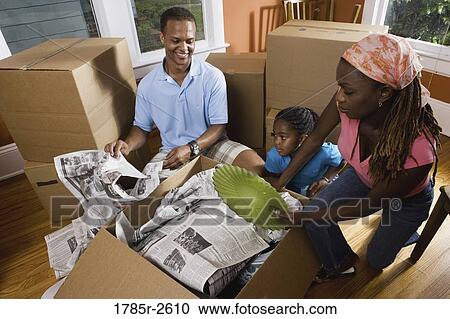 Family unpacking belongings from box View Large Photo Image Stock Image - Family unpacking belongings from box. Fotosearch
