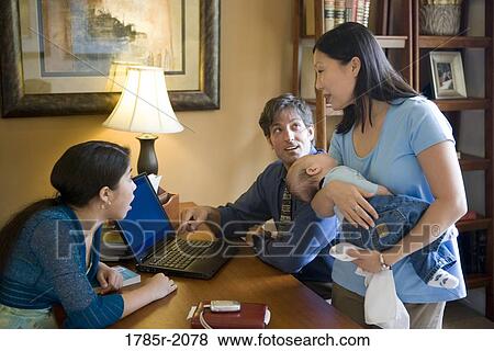 Family using laptop at home View Large Photo Image Stock Photo - Family using laptop at home. Fotosearch